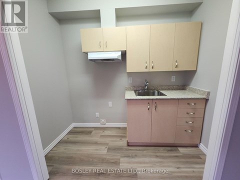 A kitchen area with wooden floors and a sink.