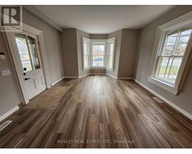 A room with wooden flooring and a large window.