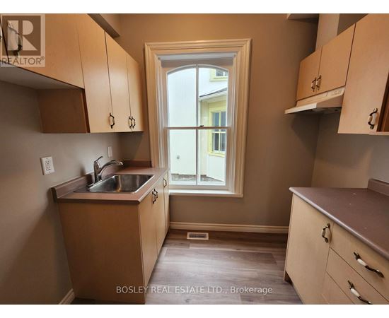 A kitchen with wooden cabinets and a window.