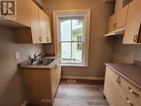 A kitchen with wooden cabinets and a window.