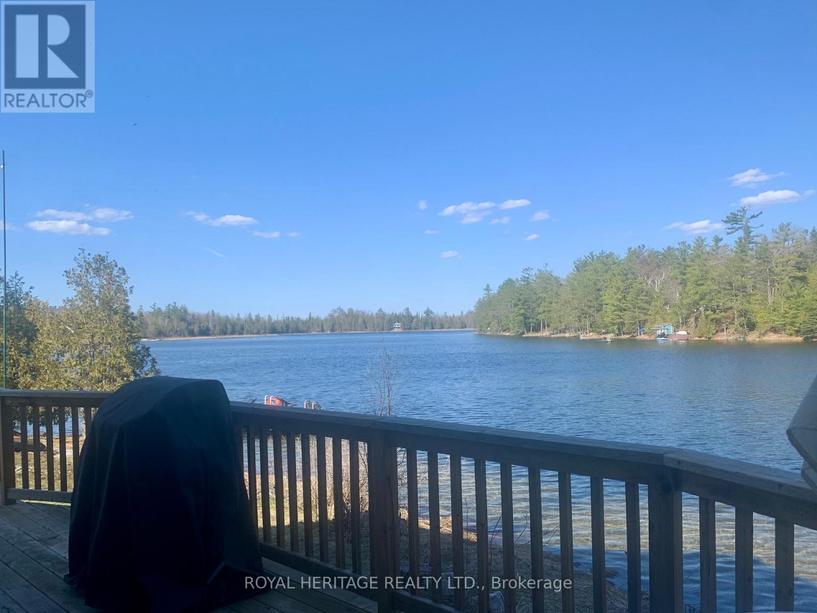A chair is on a deck overlooking a lake.