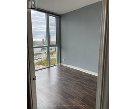 A room with a view of the city through large windows.