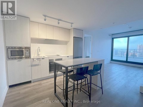 A modern kitchen with white cabinets and a large island.