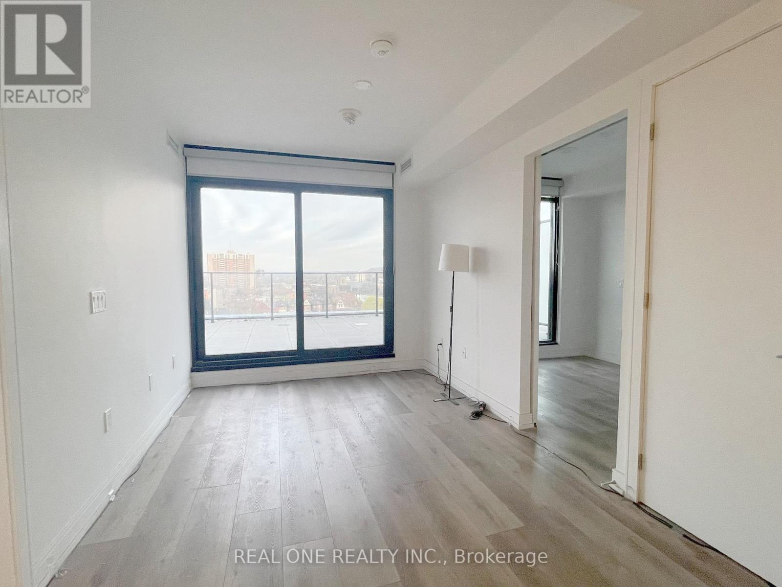 A room with a large window and wooden flooring.