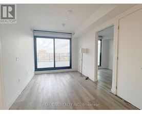 A room with a large window and wooden flooring.