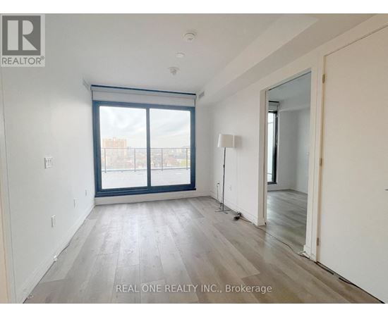 A room with a large window and wooden flooring.