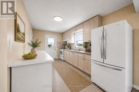 A white refrigerator is in a kitchen with wooden cabinets.