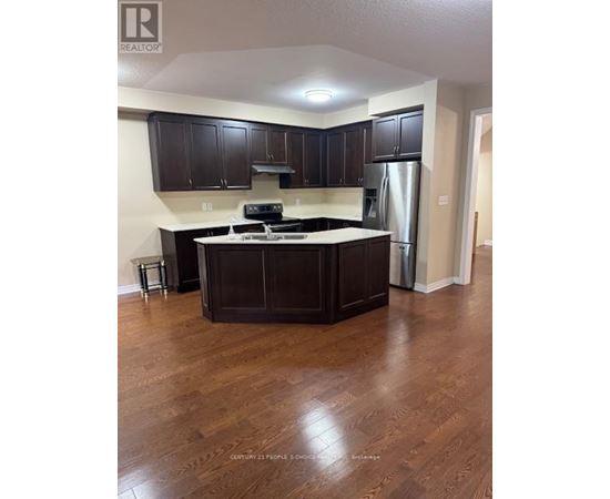 A kitchen with dark wood cabinets and a white countertop.