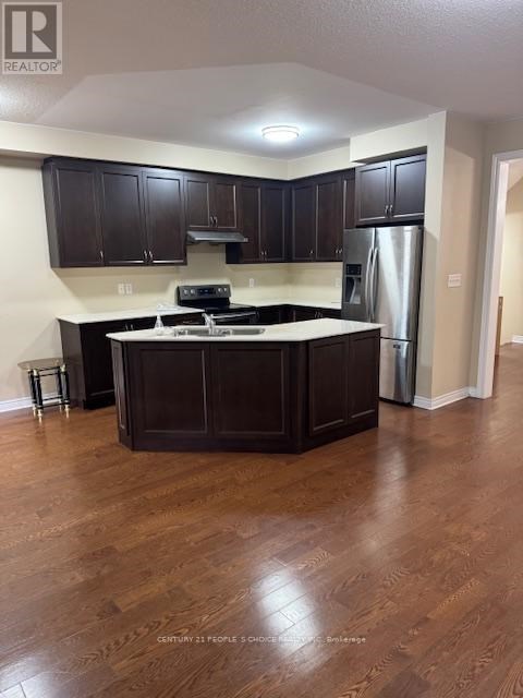 A kitchen with dark wood cabinets and a white countertop.