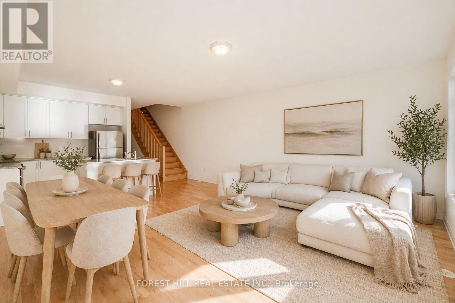 A well-lit, modern living room with a dining area and a staircase.