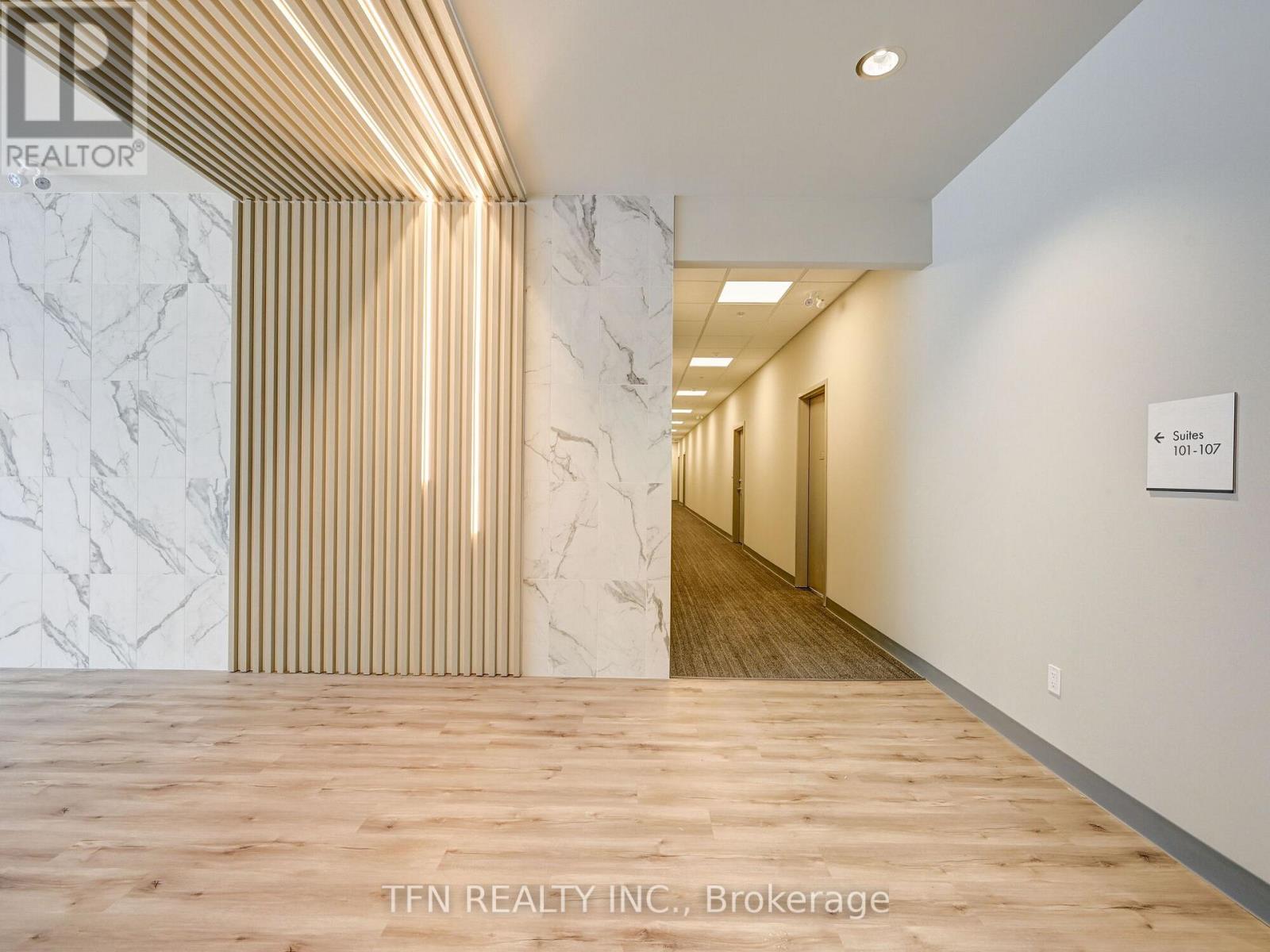 A hallway with marble walls and wooden floors.