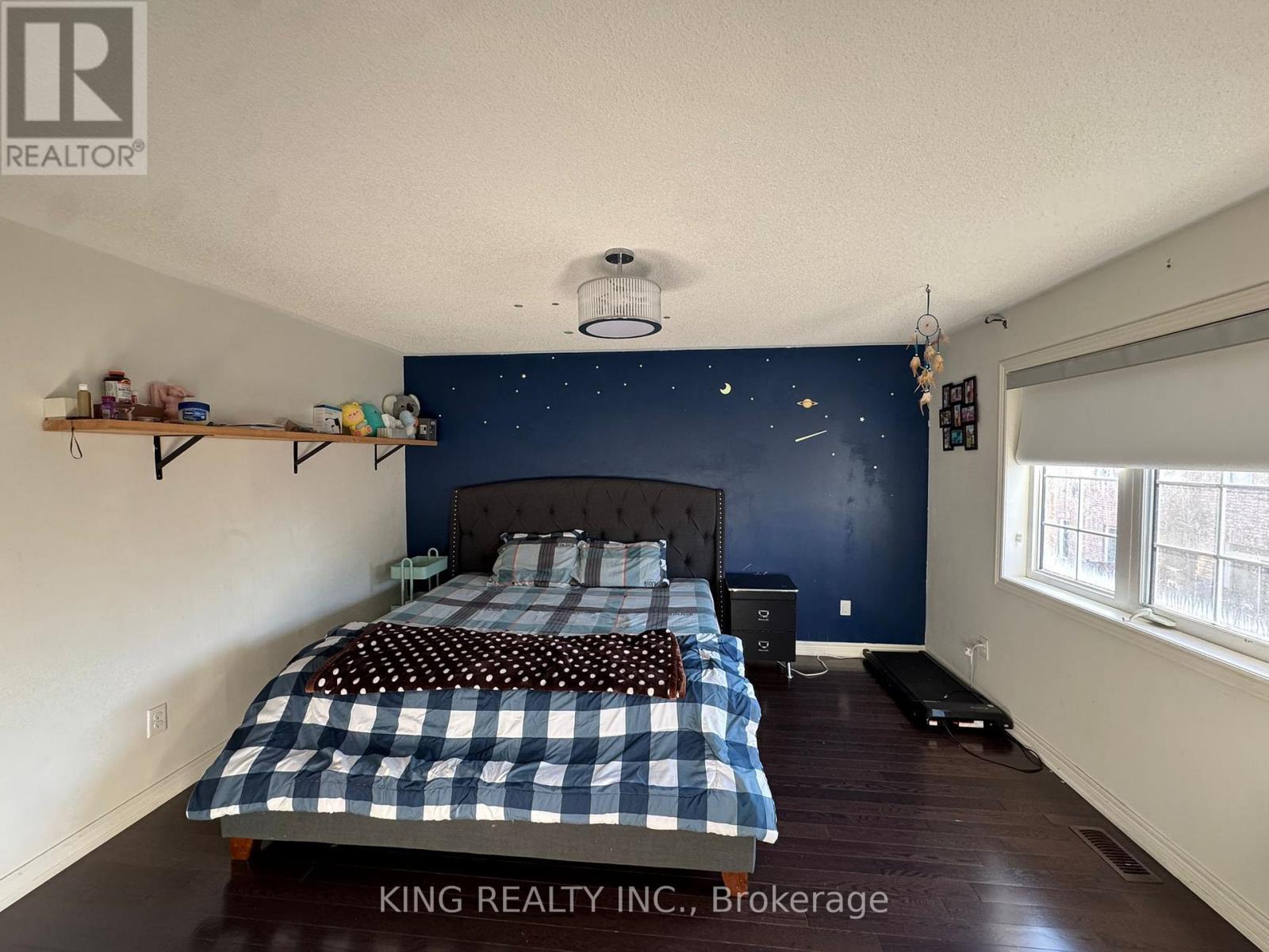 A bedroom with a bed and a nightstand.