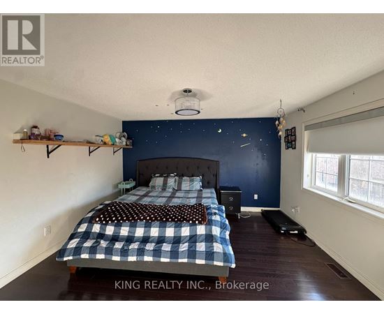 A bedroom with a bed and a nightstand.