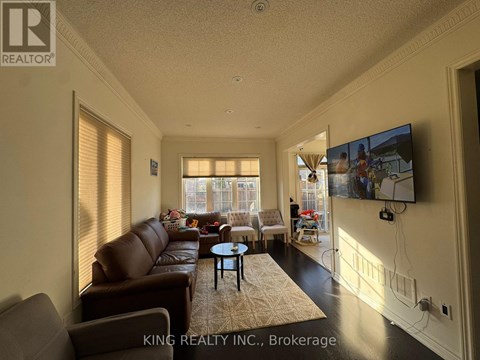 A living room with a brown leather couch and a flat screen TV mounted on the wall.