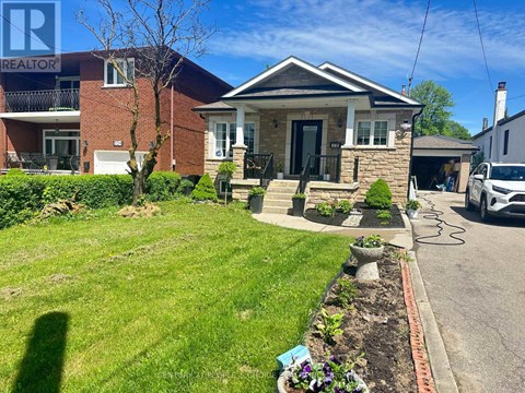 A house with a well-maintained lawn and a car parked in the driveway.