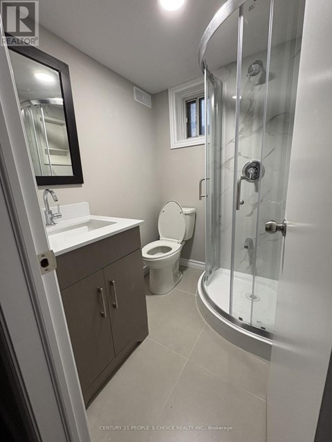 A bathroom with a toilet, sink, and shower.