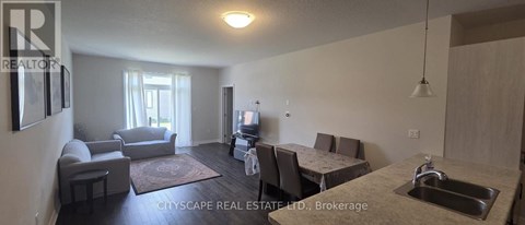 A living room with a couch, chairs, and a dining table.