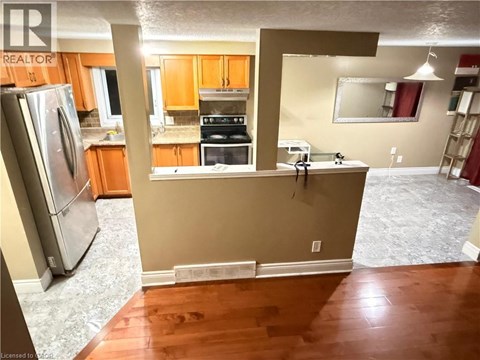 A kitchen with a refrigerator, oven, and microwave.