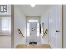 A hallway with a white door and two wooden handrails.