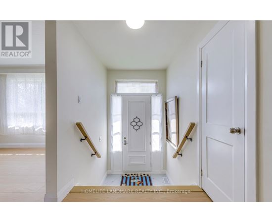 A hallway with a white door and two wooden handrails.