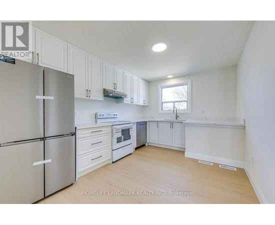 A kitchen with white cabinets and a refrigerator.
