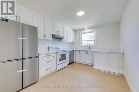 A kitchen with white cabinets and a refrigerator.