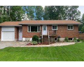 A house with a red brick exterior and a white door is for sale.