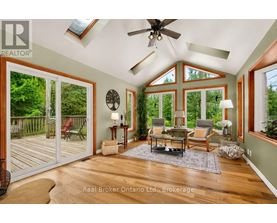 A sunroom with a ceiling fan and sliding glass doors.