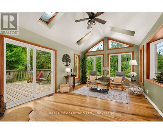 A sunroom with a ceiling fan and sliding glass doors.