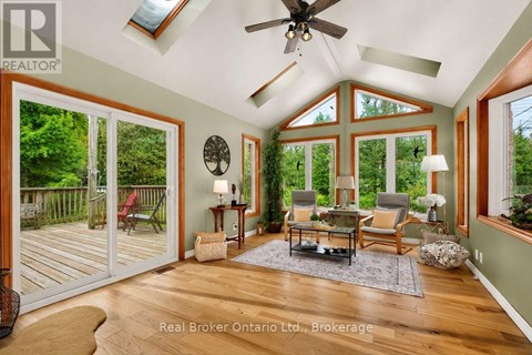 A sunroom with a ceiling fan and sliding glass doors.