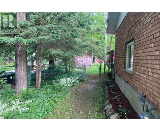 A red brick house with a green lawn and trees.