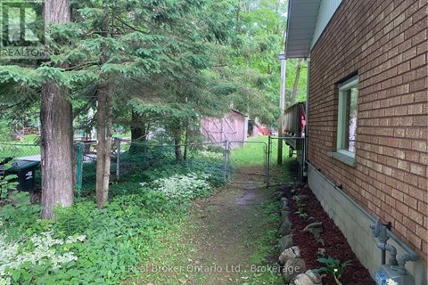 A red brick house with a green lawn and trees.