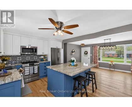 A kitchen with blue cabinets and a marble island.