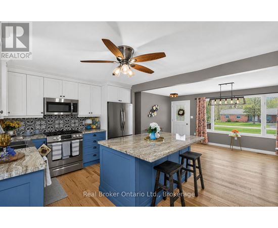 A kitchen with blue cabinets and a marble island.