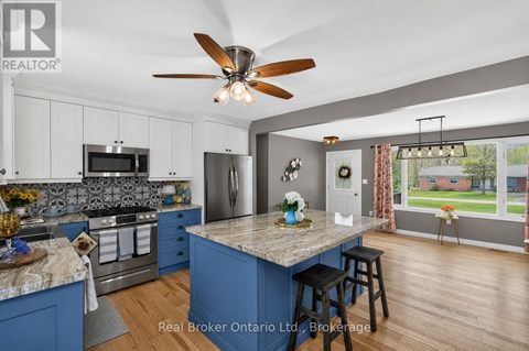 A kitchen with blue cabinets and a marble island.