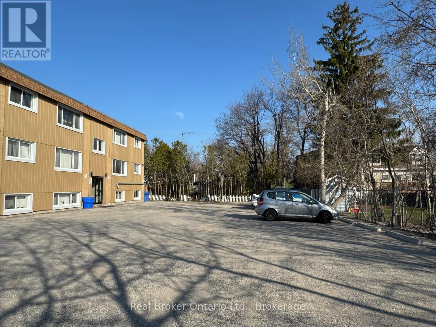 A parking lot with a car and apartment building in the background.