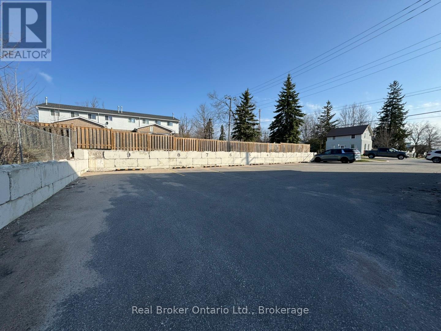 A parking lot with a Real Broker Ontario Ltd. sign in Brokerage.