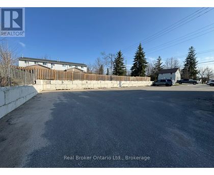 A parking lot with a Real Broker Ontario Ltd. sign in Brokerage.