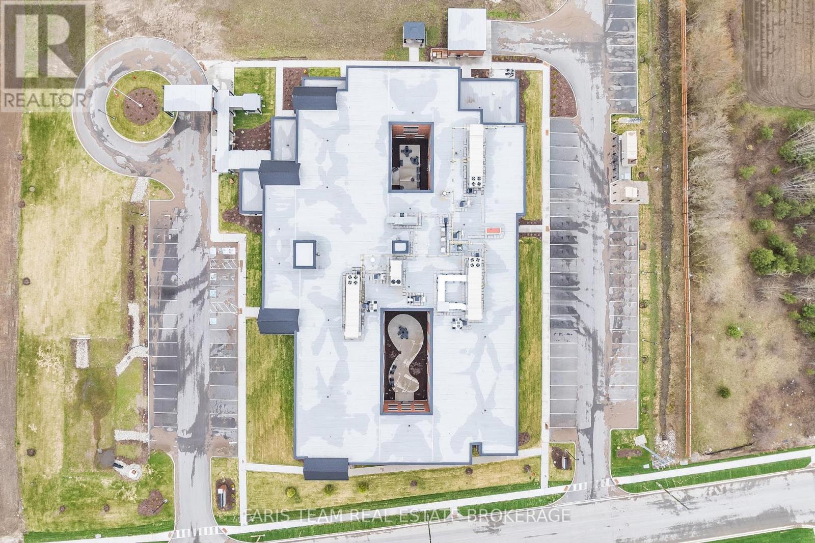 A large white building with a circular driveway in front of it.