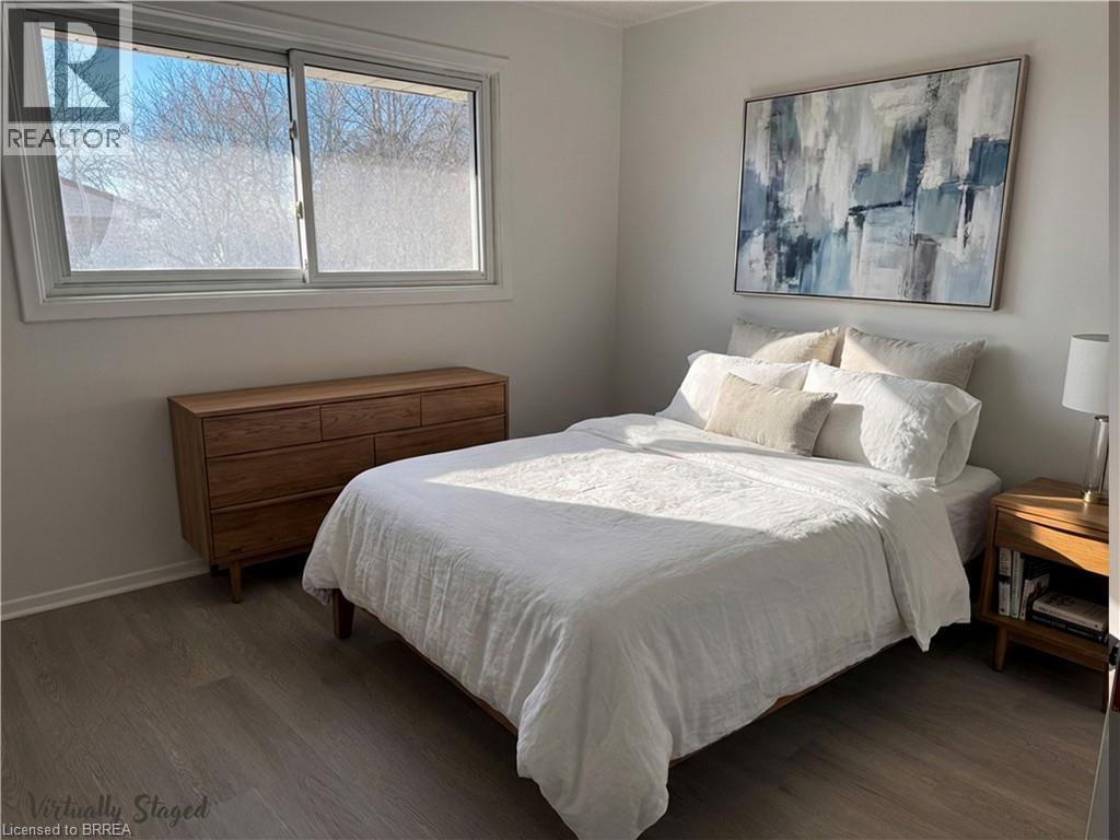 A bedroom with a bed, nightstand, and window.