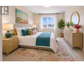 A bedroom with a large bed, a painting on the wall, and a window with a view of trees.