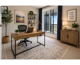 A room with a desk, chair, and a plant.