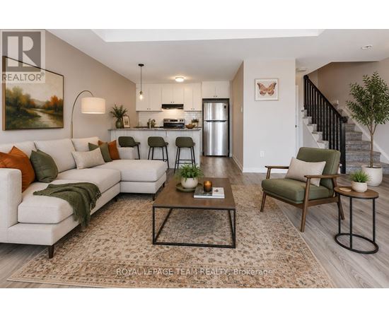 A well-lit living room with a white sofa, a coffee table, and a staircase in the background.