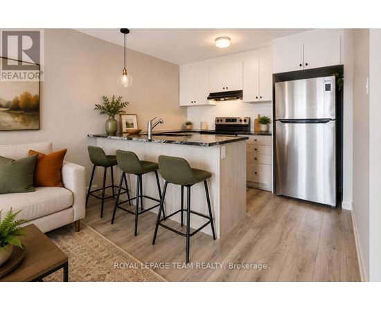 A modern kitchen with a refrigerator, sink, and bar stools.