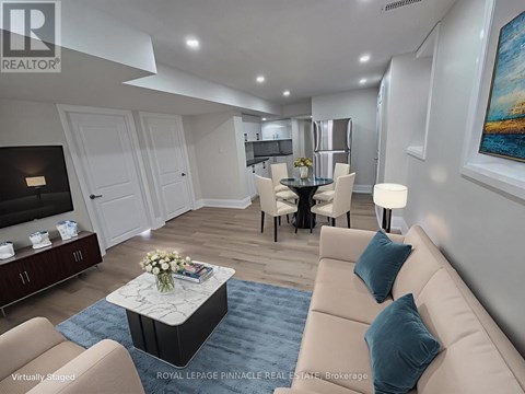 A living room with a beige sofa, a coffee table, and a painting on the wall.