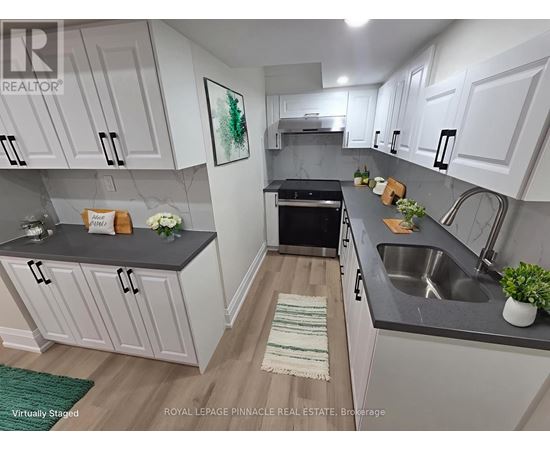 A kitchen with white cabinets and a black countertop.