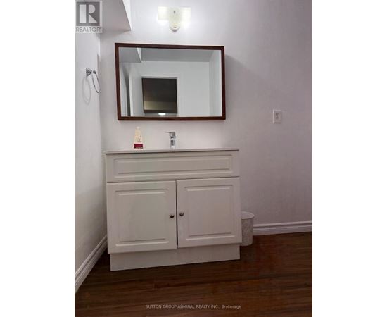 A white bathroom vanity with a mirror above it.