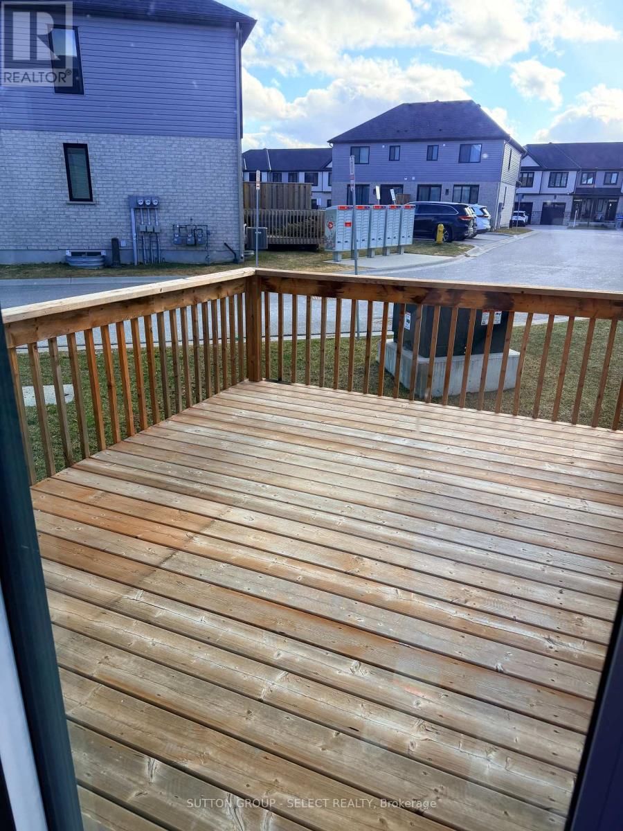 A wooden deck with a railing and a building in the background.