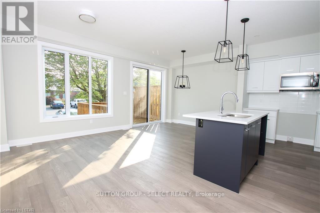 A modern kitchen with a large island and pendant lights.