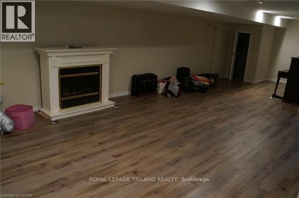 A living room with a fireplace and a wooden floor.